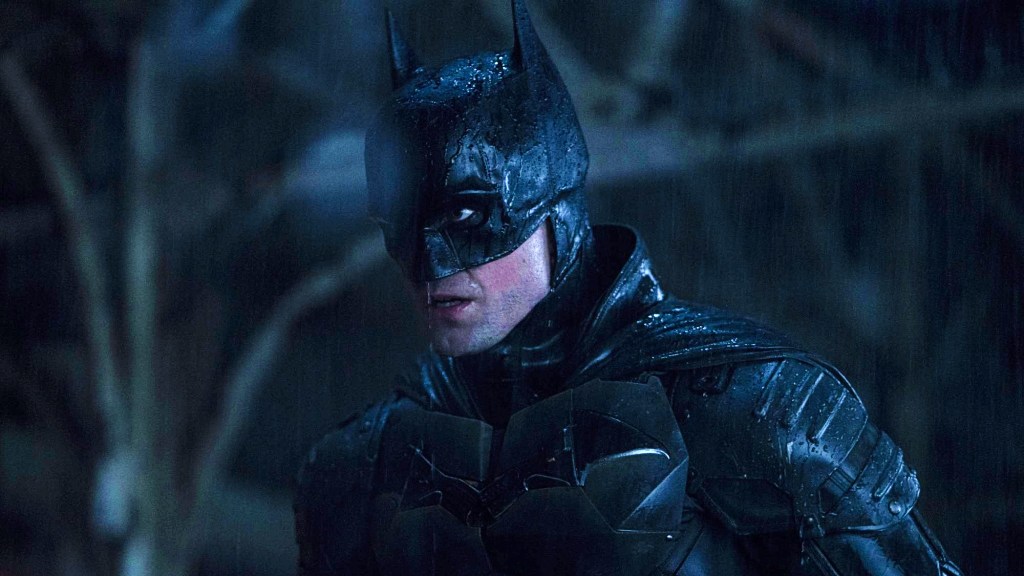 Robert Pattinson as Batman standing in the rain in The Batman