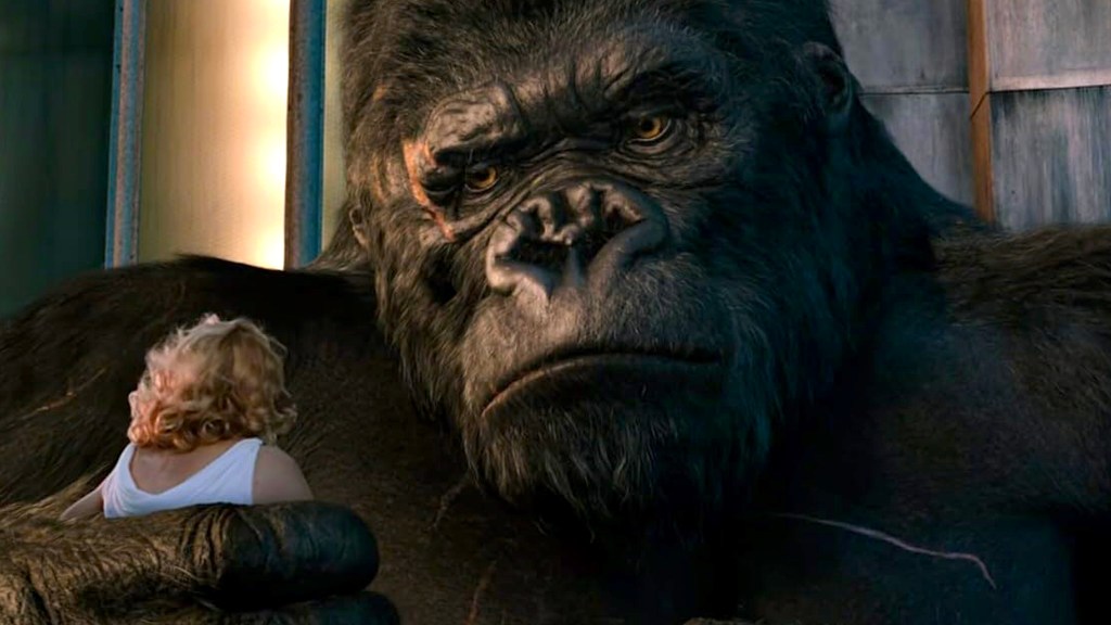 Gros plan de King Kong tenant une femme aux cheveux blonds.